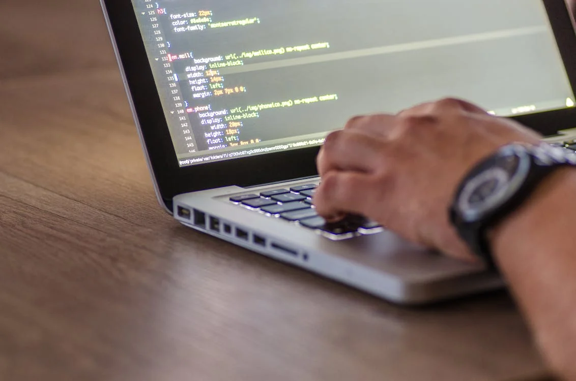 Man typing on a laptop atop a table