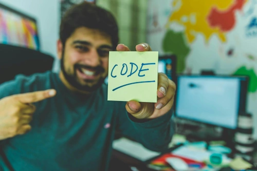 Man pointing at sticky-note with the word 'Code' on it